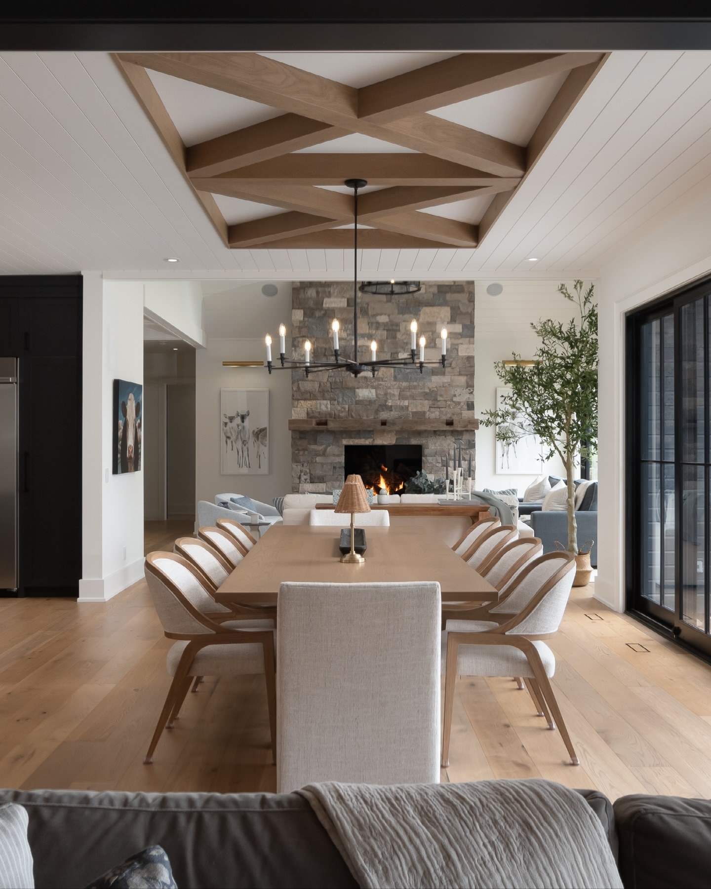 Open dining and living space with white oak coffered beam ceiling and stone fireplace, Bigwin Island cottage