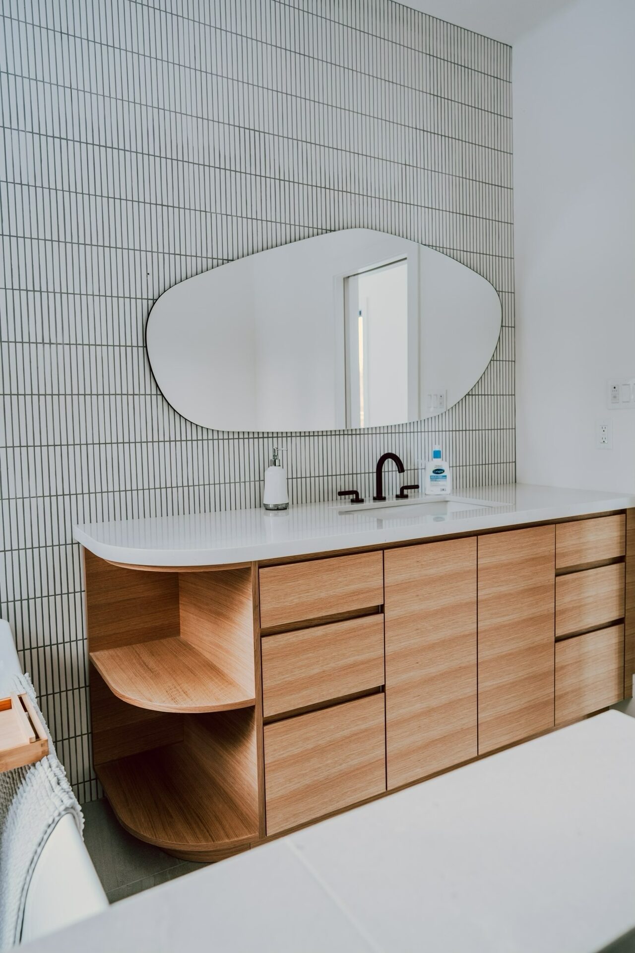 Custom bathroom vanity with organic mirror and oak cabinetry