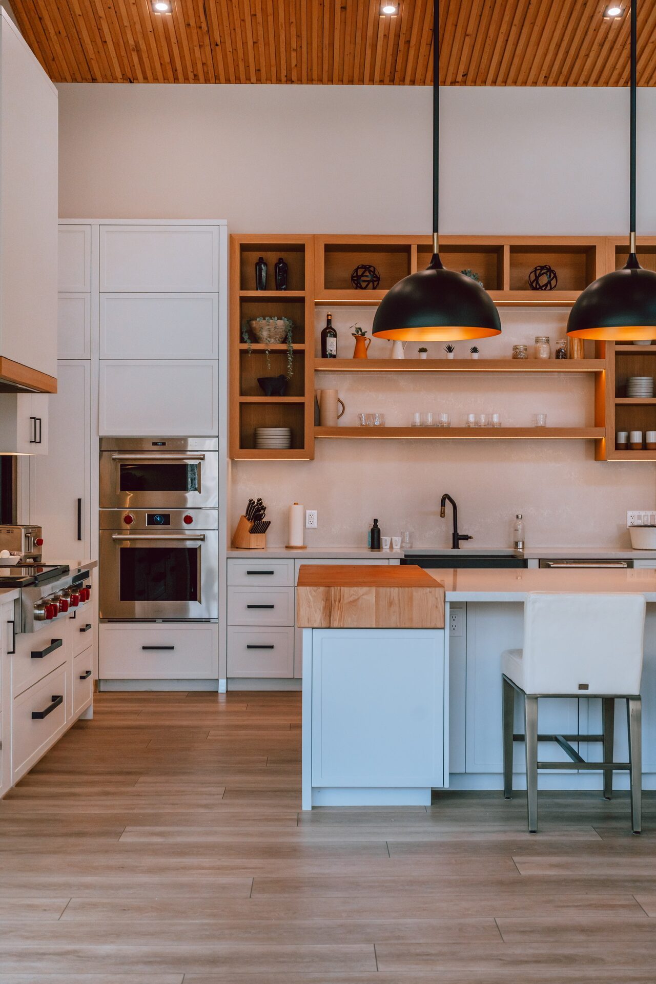 Modern kitchen with black pendant lighting and wood ceiling